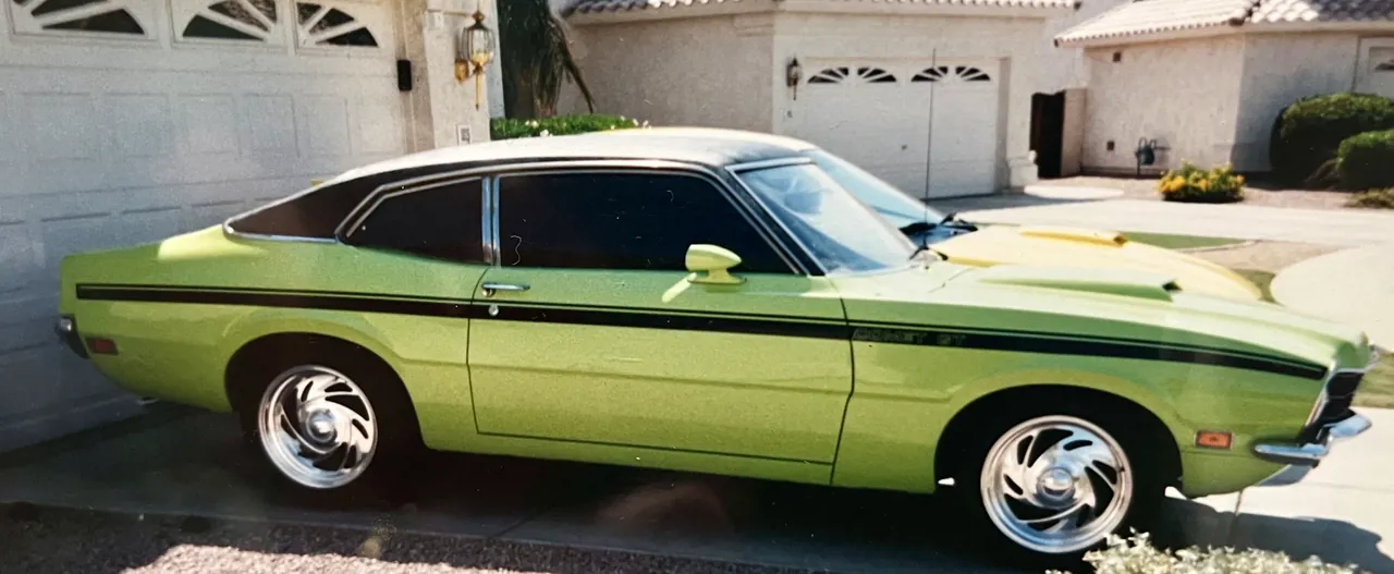 A green Ford Gran Torino two-door with a black stripe along the body